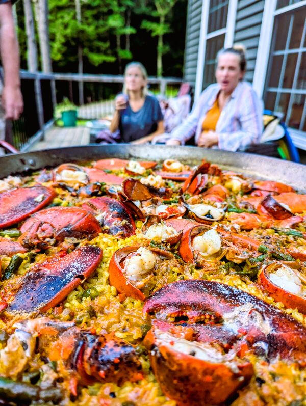 two ladies looking at a paella lobster dish